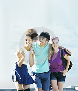 Cute group of teenages at the building of university with books huggings, back to school