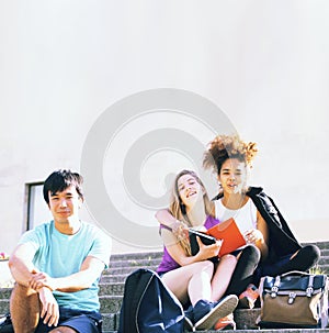 Cute group of teenages at the building of university with books huggings, back to school