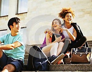 Cute group of teenages at the building of university with books huggings, back to school