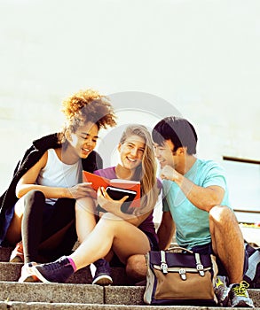 Cute group of teenages at the building of university with books huggings, back to school