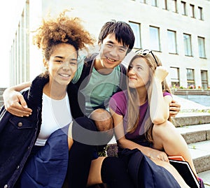 Cute group of teenages at the building of university with books huggings, back to school