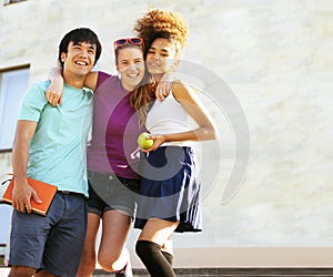 Cute group of teenages at the building of university with books huggings, back to school