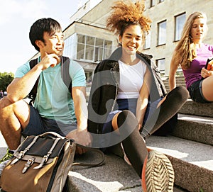 Cute group of teenages at the building of university with books huggings, back to school