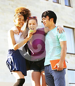 Cute group of teenages at the building of university with books huggings, back to school