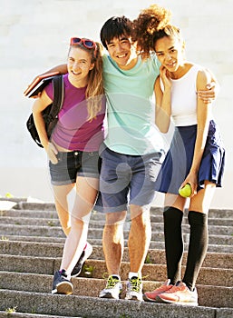 Cute group of teenages at the building of university with books huggings, back to school