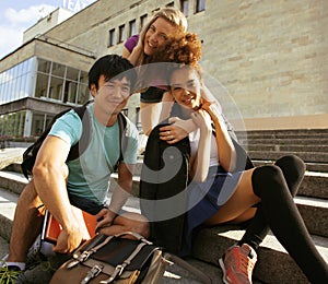 Cute group of teenages at the building of university with books huggings, back to school