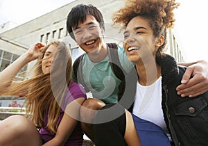 Cute group of teenages at the building of university with books huggings, back to school