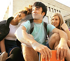 Cute group of teenages at the building of university with books huggings, back to school