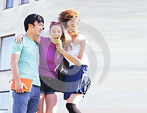 Cute group of teenages at the building of university with books huggings, back to school