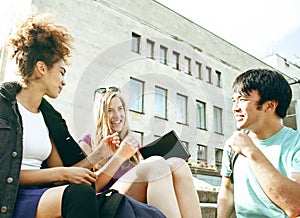 cute group of teenages at the building of university with books huggings, diversity nations, having lunch closeup