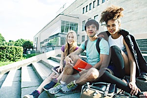 Cute group of teenages at the building of university with books huggings, diversity nations real students lifestyle