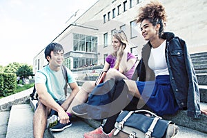 Cute group of teenages at the building of university with books huggings, diversity nations real students lifestyle