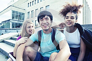 Cute group of teenages at the building of university with books huggings, diversity nations real students lifestyle