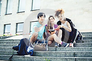 Cute group of teenages at the building of university with books huggings, diversity nations real students lifestyle