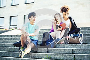 Cute group of teenages at the building of university with books huggings, diversity nations real students lifestyle