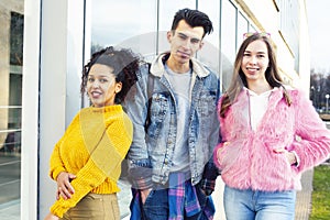 Cute group of teenages at the building of university with books huggings, diversity nations real students lifestyle