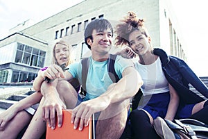 Cute group of teenages at the building of university with books huggings, diversity nations real students lifestyle