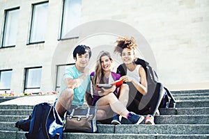 Cute group of teenages at the building of university with books huggings, diversity nations real students lifestyle