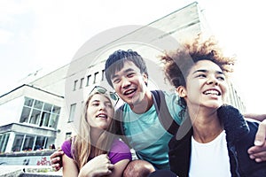 Cute group of teenages at the building of university with books huggings, diversity nations real students lifestyle