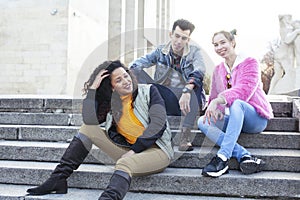 Cute group of teenages at the building of university with books huggings, diversity nations real students lifestyle