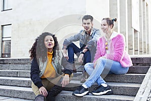 Cute group of teenages at the building of university with books huggings, diversity nations real students lifestyle