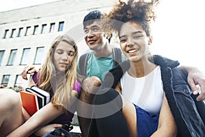 Cute group of teenages at the building of university with books huggings, diversity nations students lifestyle