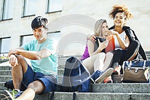 Cute group of teenages at the building of university with books huggings, diversity nations students lifestyle