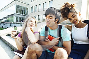 Cute group of teenages at the building of university with books huggings, diversity nations students lifestyle