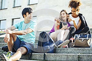 Cute group of teenages at the building of university with books huggings, diversity nations students lifestyle