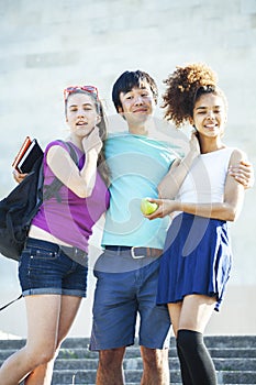 Cute group of teenages at the building of university with books huggings, diversity nations students lifestyle