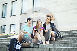 Cute group of teenages at the building of university with books huggings, diversity nations students lifestyle