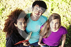 Cute group of teenages at the building of university with books huggings, smiling, back to school