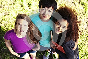 Cute group of teenages in green park at summer with books huggings, diversity nations real students lifestyle