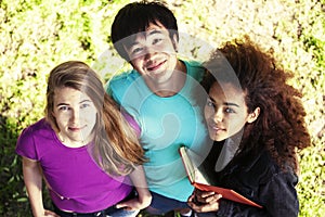 Cute group of teenages in green park at summer with books huggings, diversity nations real students lifestyle