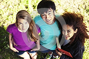 Cute group of teenages in green park at summer with books huggings, diversity nations real students lifestyle