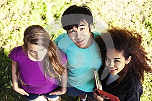 Cute group of teenages in green park at summer with books huggings, diversity nations real students lifestyle