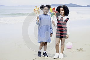 Cute groups of kids have fun together on sandy summer with blue sea, happy childhood friends play on tropical beach,  girl