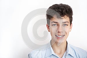A cute guy smiles at the white background