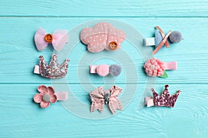 Cute hair clips on blue wooden table, flat lay