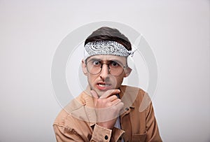 Funny young man with glasses looks into the camera