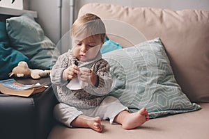 Cute happy 11 month baby boy playing at home, lifestyle capture in cozy interior