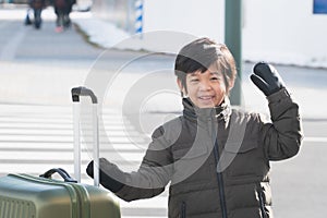 Cute happy Asian child with a suitcase