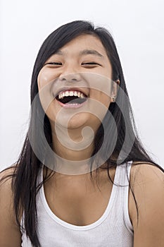 Cute happy asian girl on isolated background laughing