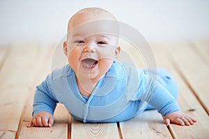 Cute happy baby boy crawling on the floor