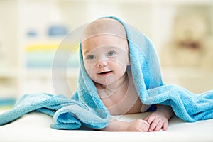 Cute happy baby boy hidden in blue towel after