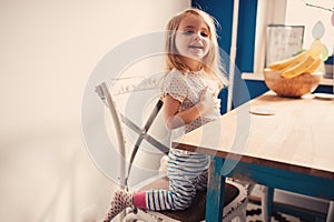 Cute happy baby girl having fun on the kitchen