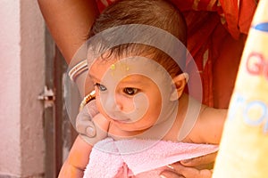 Cute happy baby in pink bath towel close up