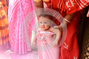 Cute happy baby in pink bath towel close up