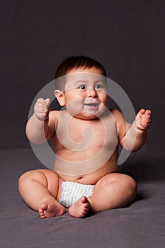 Cute happy baby sitting wearing diaper