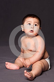 Cute happy baby sitting wearing diaper
